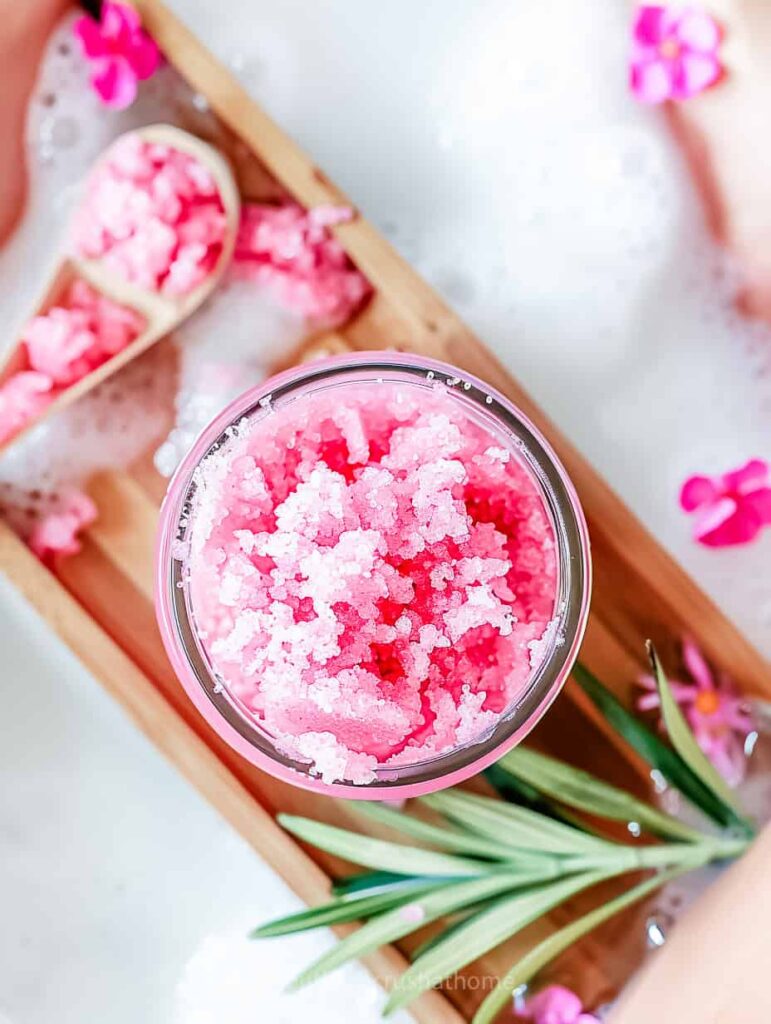 pink sugar scrub on a wooden bath tray