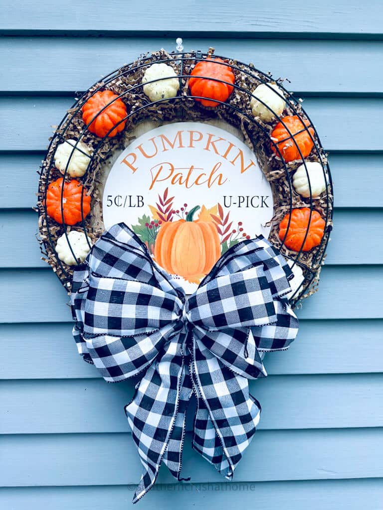 finished hanging Dollar Tree Pumpkin Wreath on blue shiplap