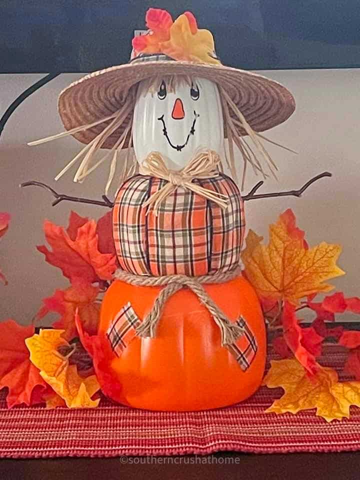 scarecrow stacking pumpkins