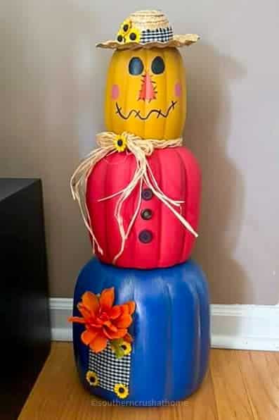 scarecrow stacking pumpkins