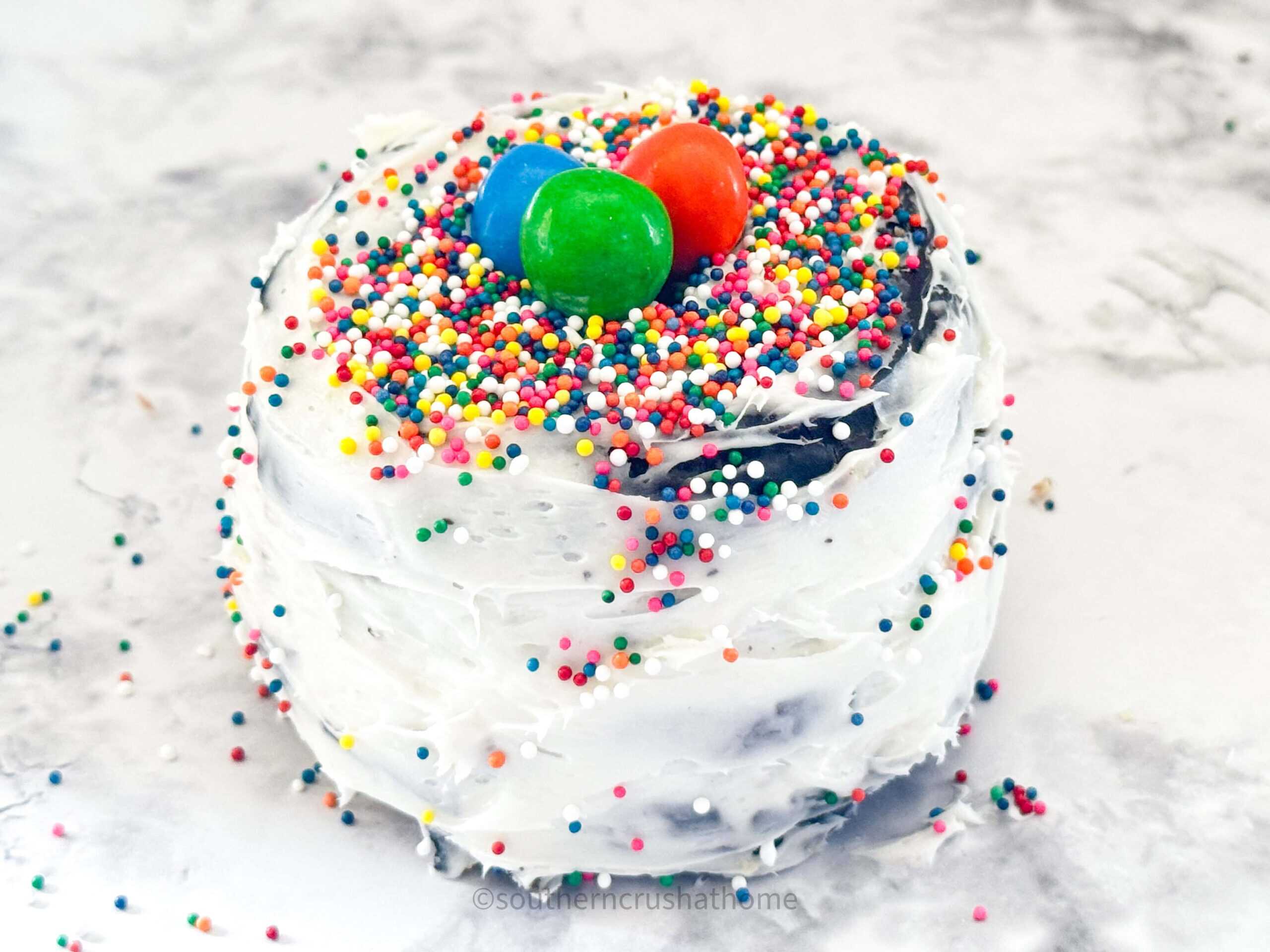 m&m candies and sprinkles on top of mini cake using stacked donuts