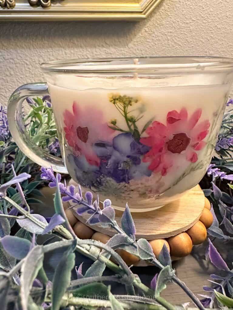 up close of finished tea cup candle with dried flowers on the side
