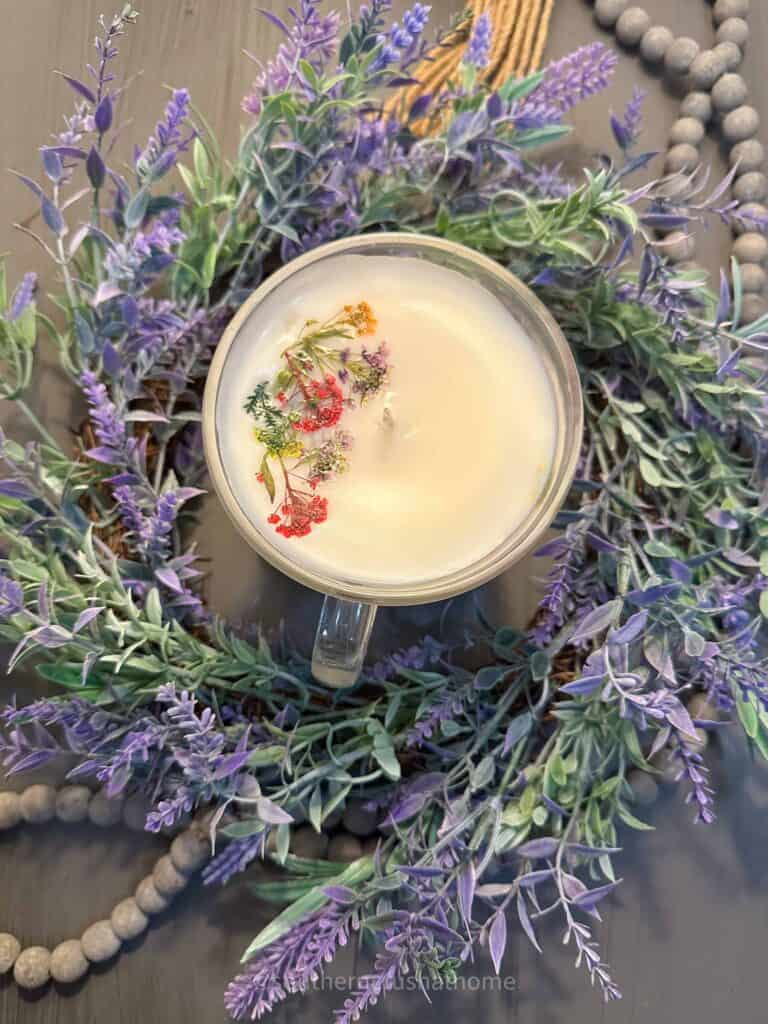 overhead view of tea cup candle with dried flowers on top surrounded by lavender wreath