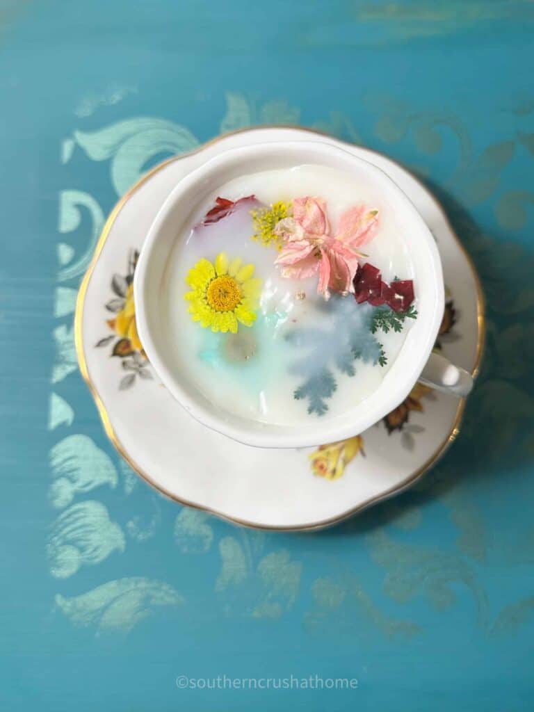 overhead view of tea cup candle with dried flowers on top