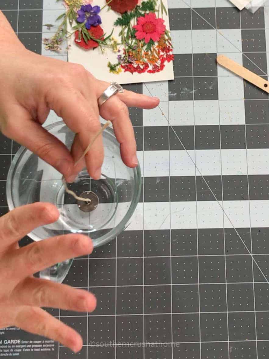 placing wick in center of tea cup for candle