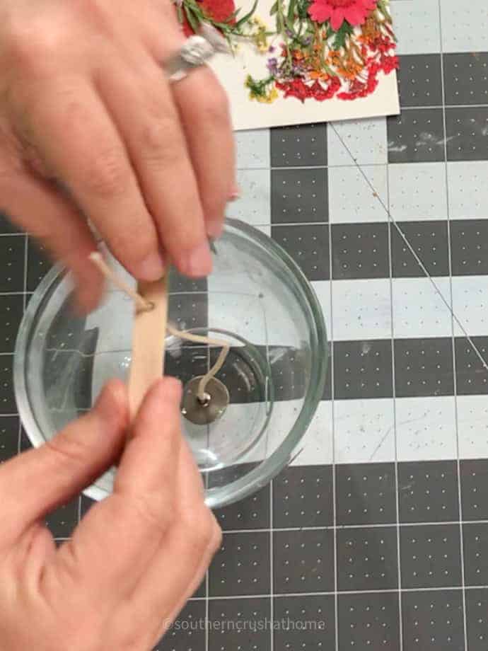 adding popsicle stick to candle wick