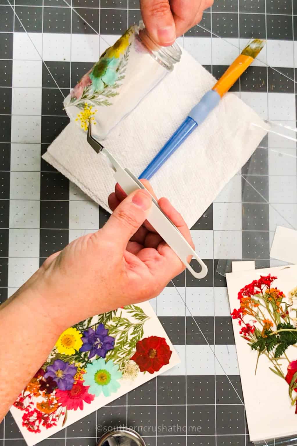 applying dried flowers with tweezers