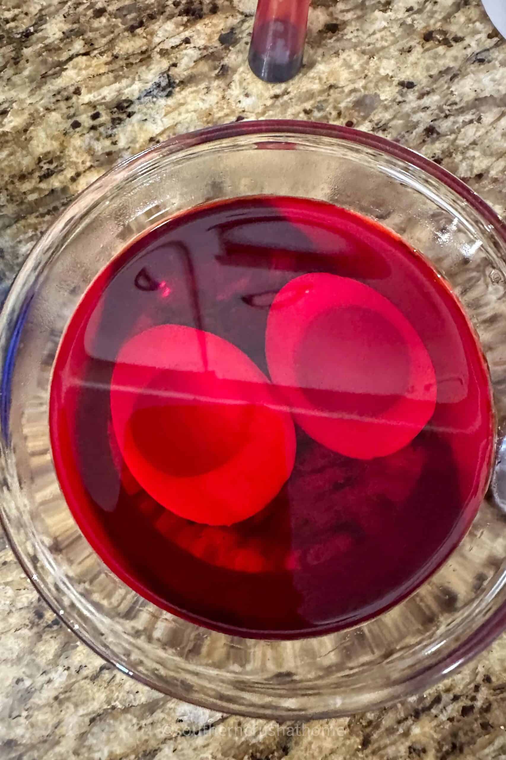 egg white halves soaking in red food coloring