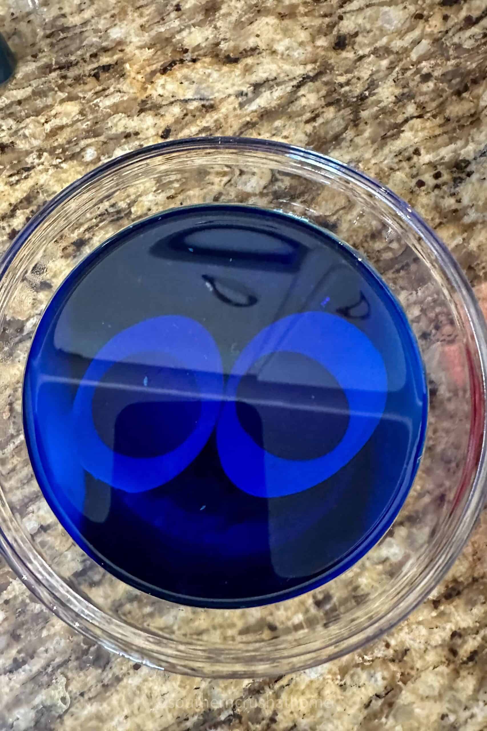 egg white halves soaking in blue food coloring