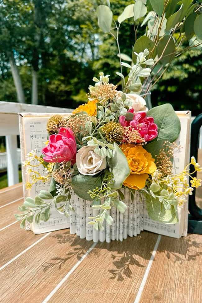 brightly colored flowers in book page vase