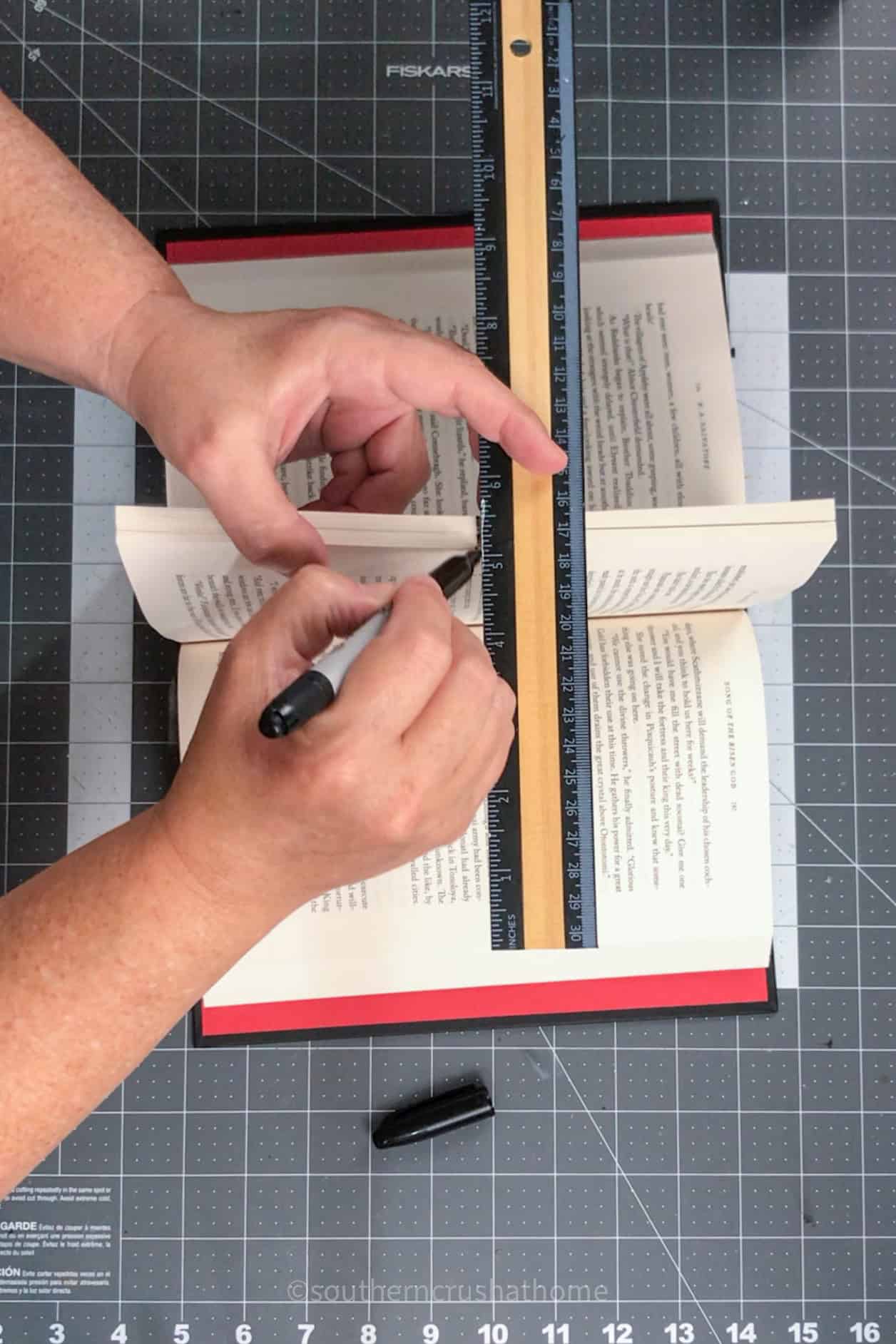 marking the book in the middle with a ruler