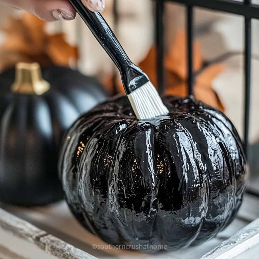 applying glue to black pumpkin