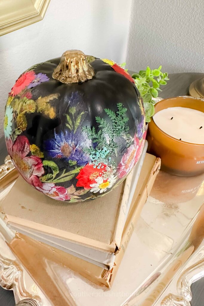 side view of decoupage pumpkin on book stack