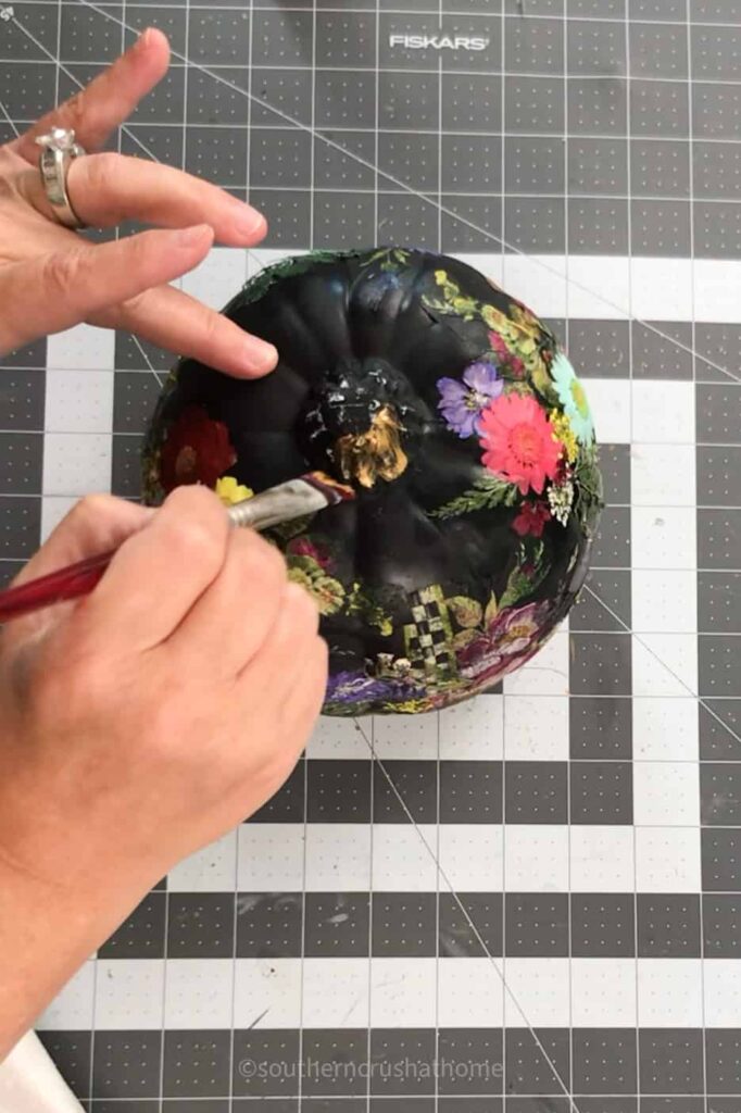 adding gold paint to the stem of the pumpkin