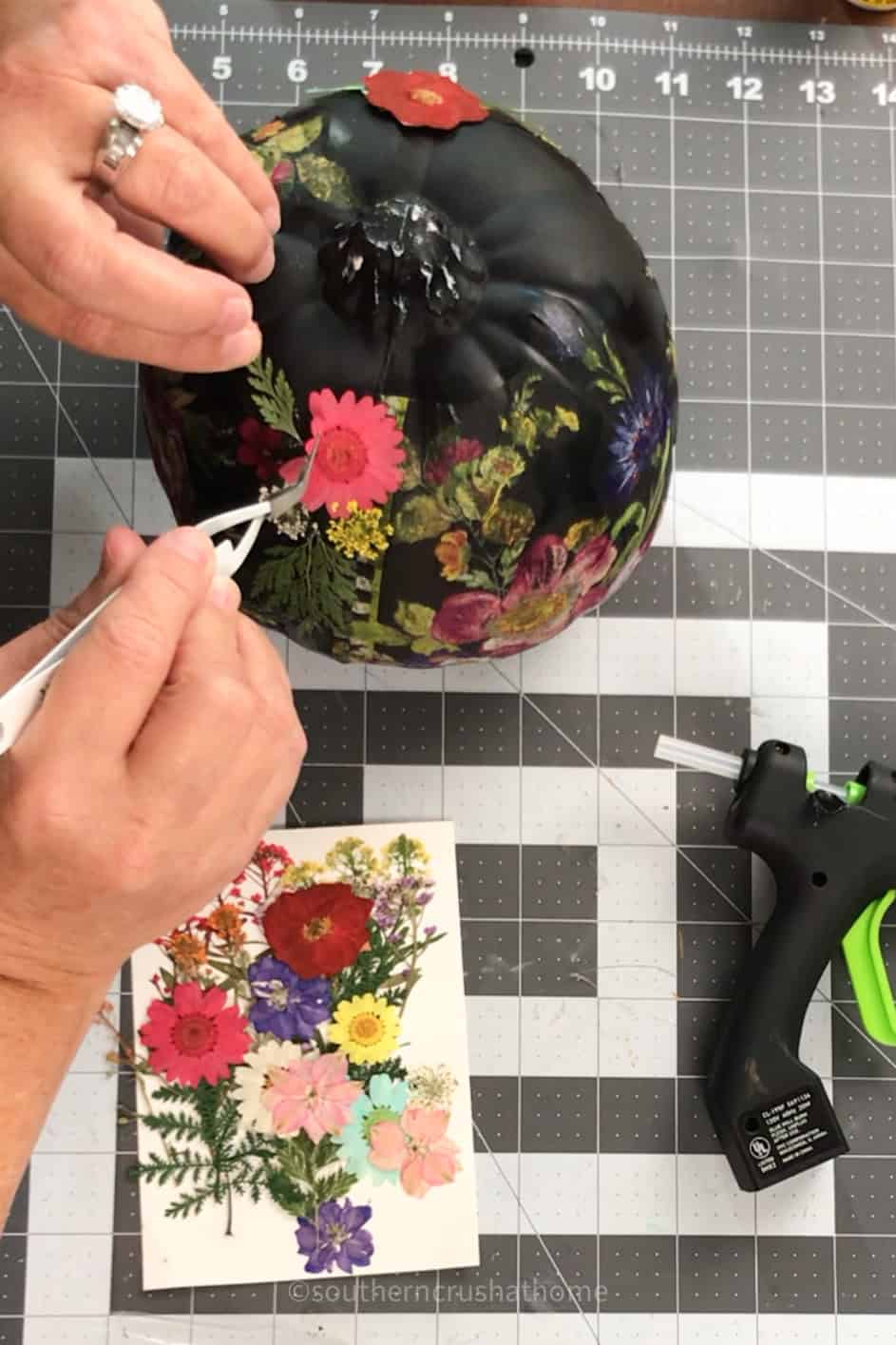 using tweezer to position pressed flowers