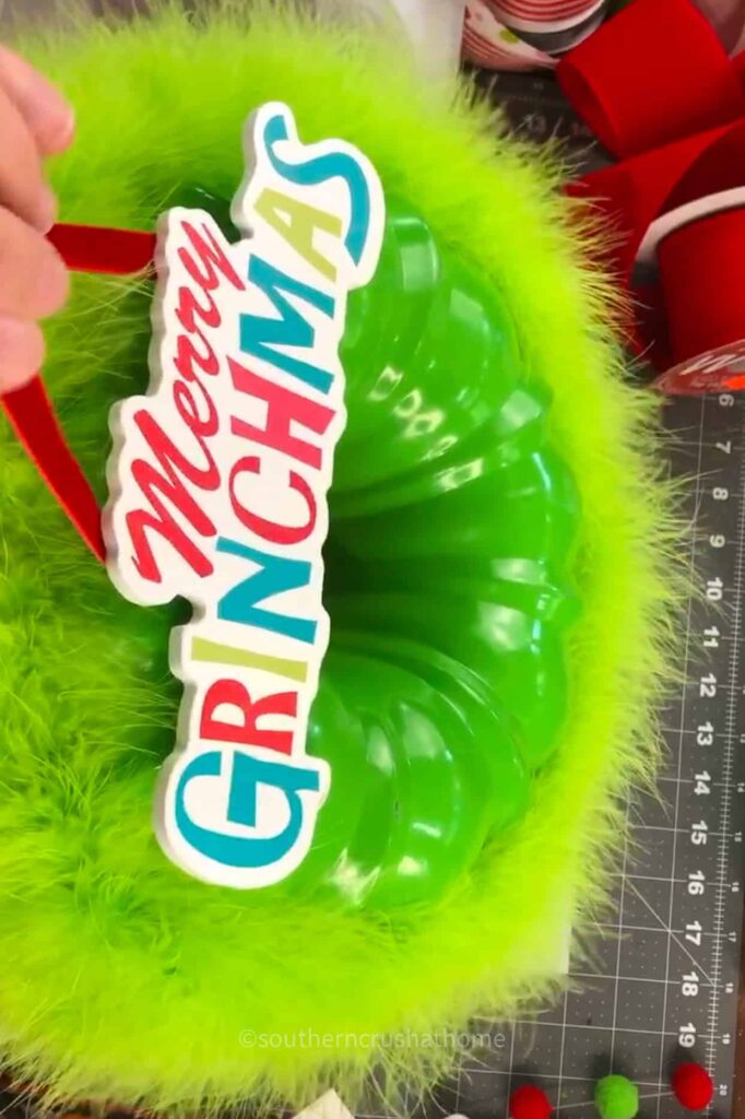 adding merry grinchmas sign to grinch wreath