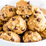 A plate of no-bake peanut butter oat balls with chocolate chips and flax seeds.